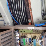 These wiring looms run to the overhead panel, behind the library in a 747-400 simulator.